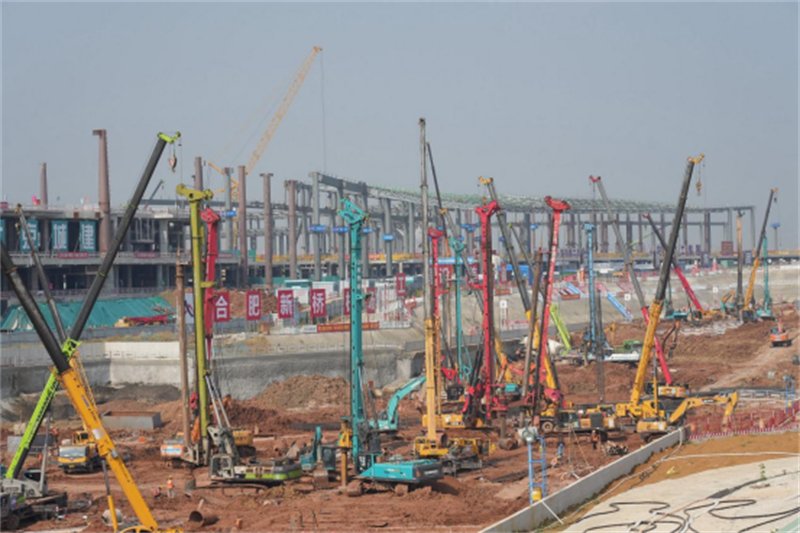 施工现场林立的打桩机，背后是正在施工中的合肥新桥机场T2航站楼。.png